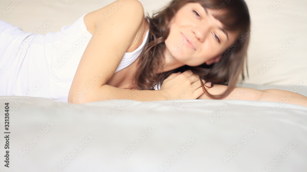 Young beautiful happy woman lying in bed Young beautiful happy woman lying in bed