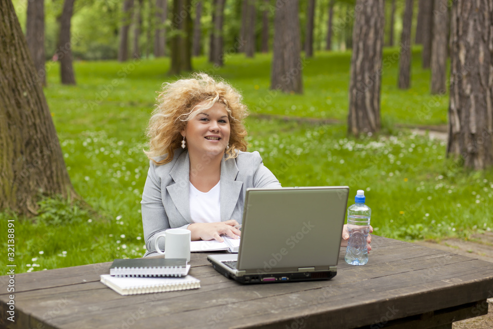 Woman using laptop in park Woman using laptop in park