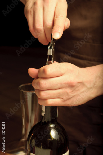 A sommelier opening wine bottle for blind winetasting