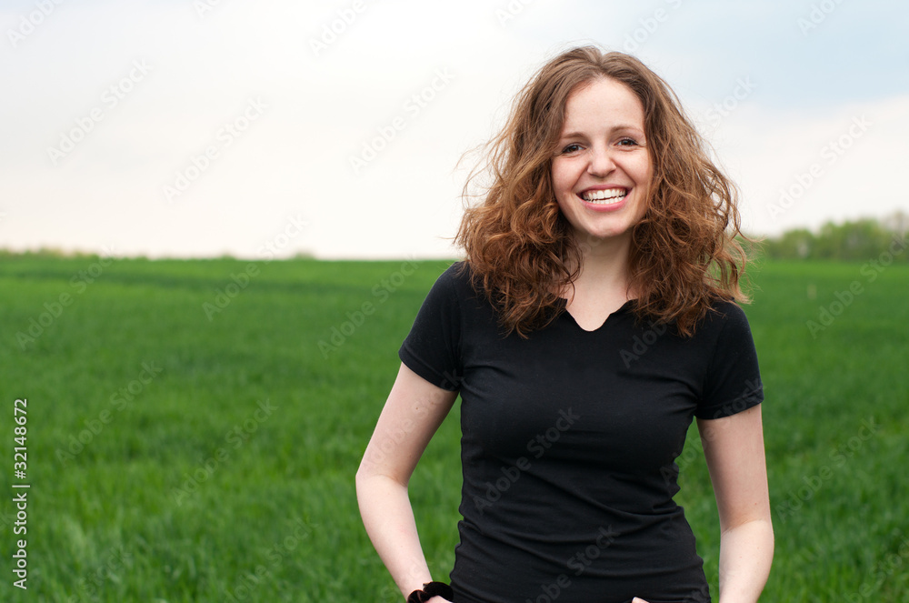 Happy readhead girl outdoors on the green field