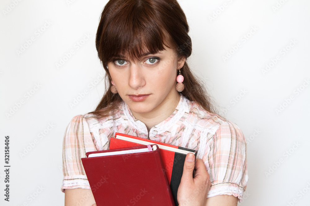 A beautiful young student holding workbook. She is upset and sad