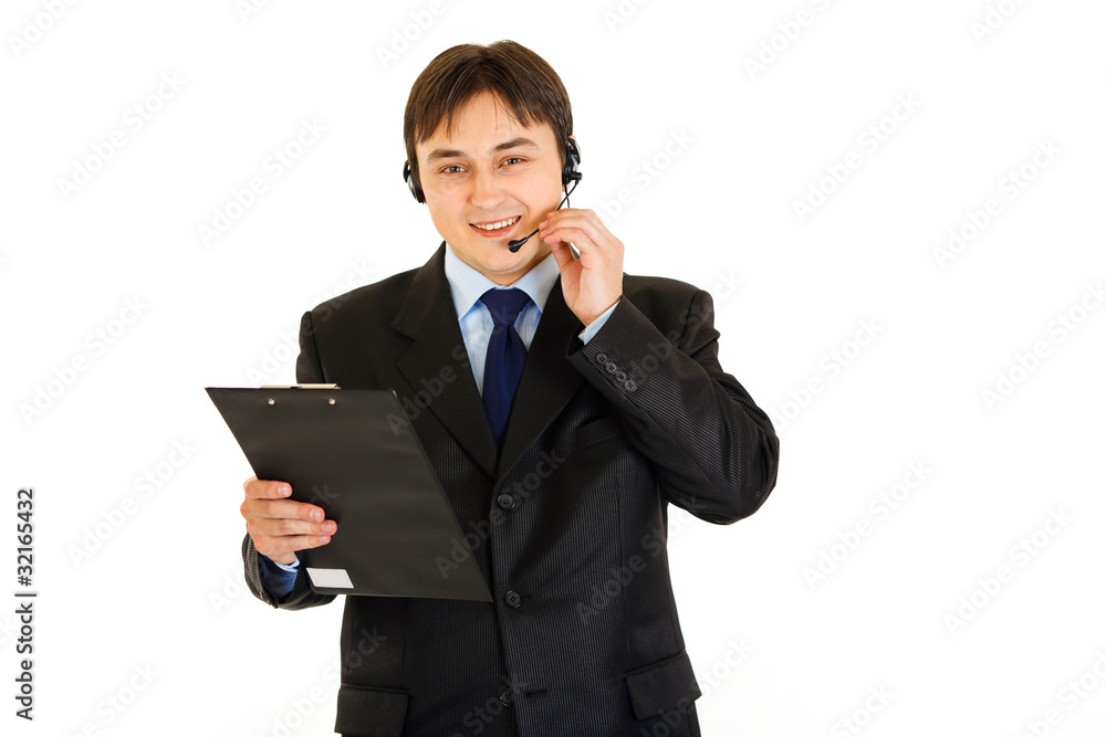 Cheerful young businessman with headset holding clipboard Cheerful young businessman with headset holding clipboard