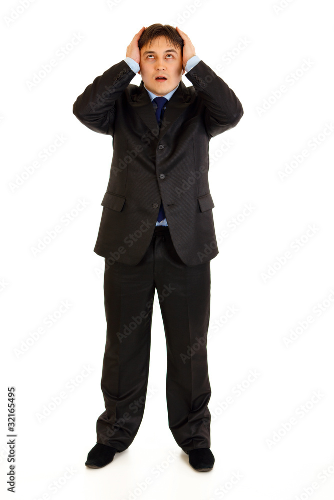Shocked businessman holding hands near head Shocked businessman holding hands near head