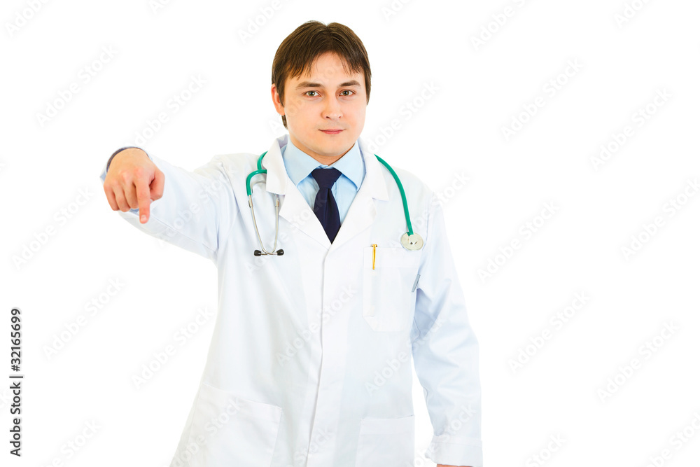 Smiling medical doctor pointing finger down isolated on white. Smiling medical doctor pointing finger down isolated on white.