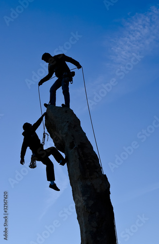 Fotografie Team of climbers reaching the summit.
