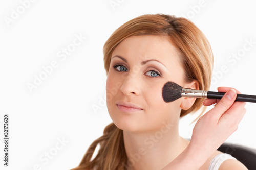 Make-up artist applying make up to an attractive blond-haired wo