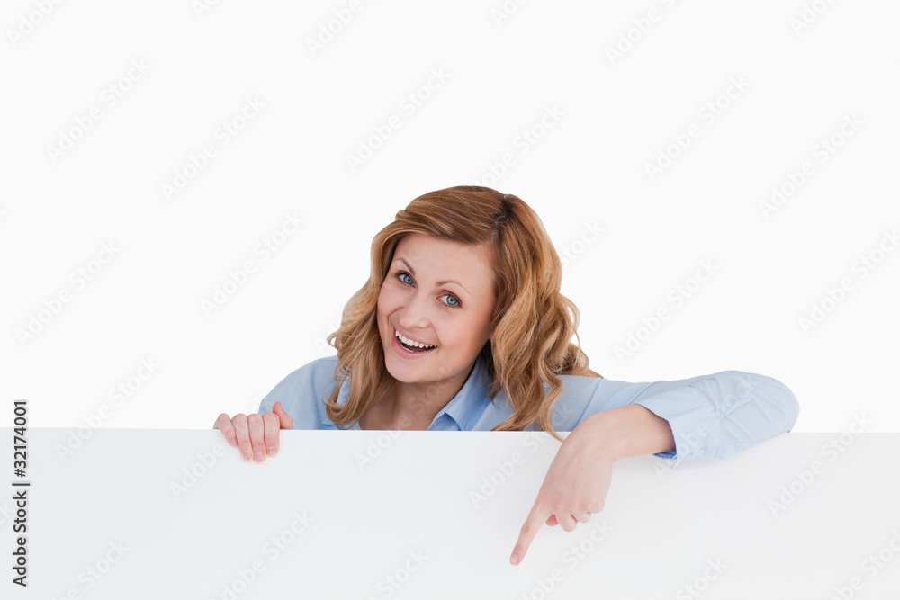 Happy blond-haired woman standing behind a white board Happy blond-haired woman standing behind a white board