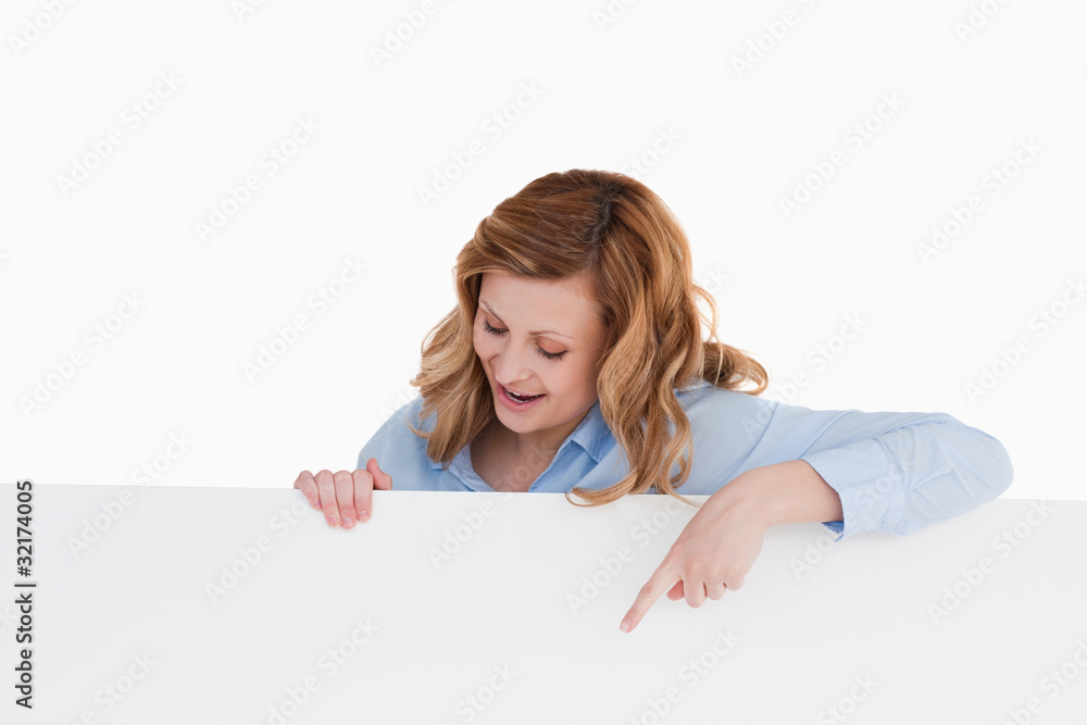 Attractive blond-haired woman standing behind a white board Attractive blond-haired woman standing behind a white board