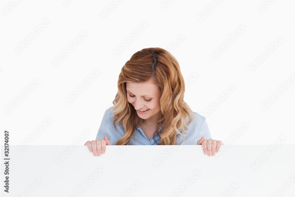Blond-haired woman standing behind an empty white board Blond-haired woman standing behind an empty white board