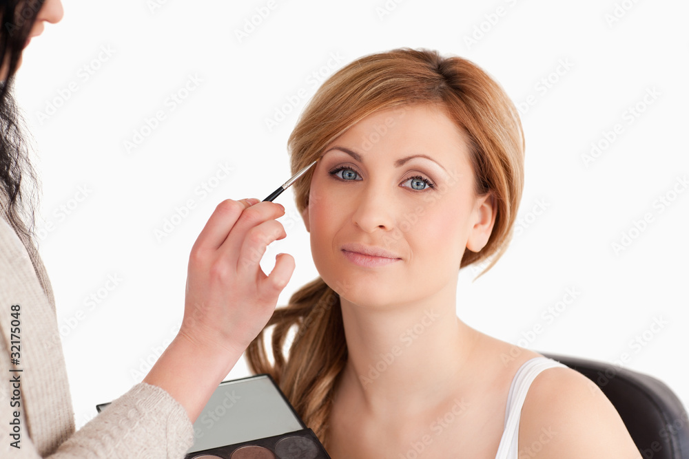 Make-up artist applying make up to a blond-haired woman Make-up artist applying make up to a blond-haired woman