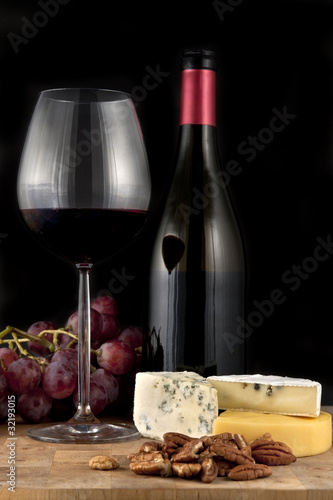 Glass of red wine with bottle and food