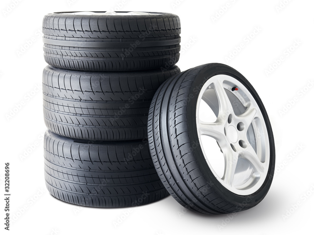 Isolated set of low section summer tyres with one wheel in front Isolated set of low section summer tyres with one wheel in front