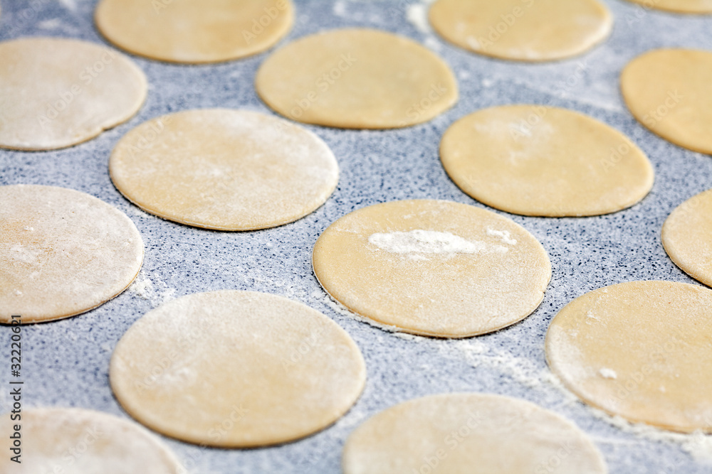 round shape of the dough with flour on the table