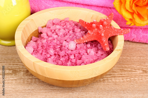 Bath aromatic salt, rose and sea stars on wooden background