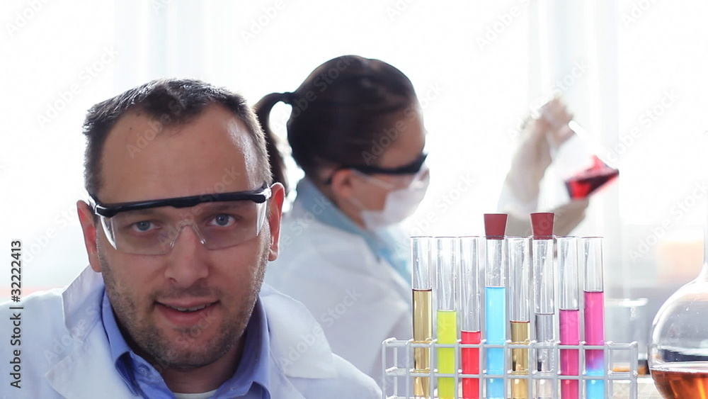 Portrait scientist in laboratory, female coworker in background Portrait scientist in laboratory, female coworker in background