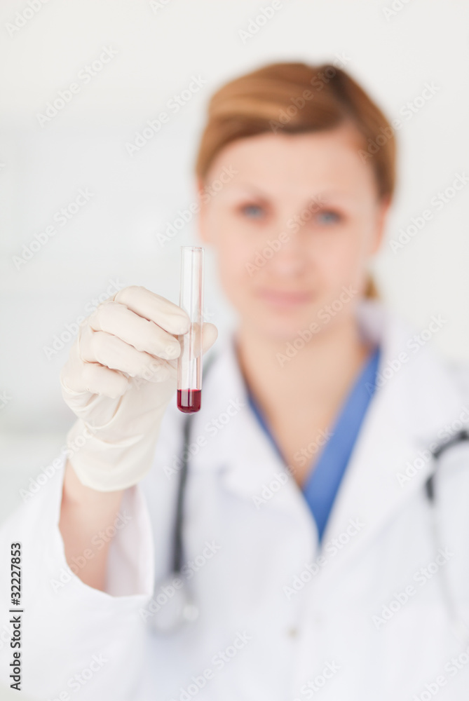 Female scientist looking at the camera while holding a test tube Female scientist looking at the camera while holding a test tube