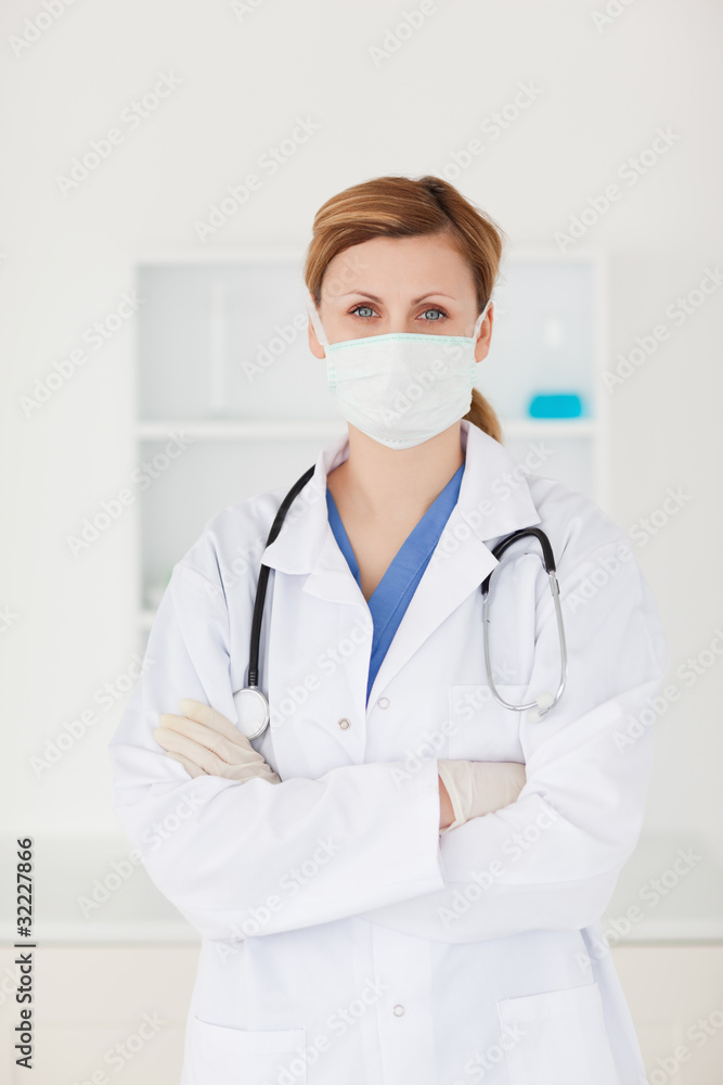 Blond-haired scientist with a mask and a stethoscope looking at Blond-haired scientist with a mask and a stethoscope looking at