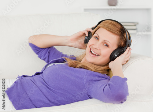 Joyful red-haired woman listening to music and enjoying the mome