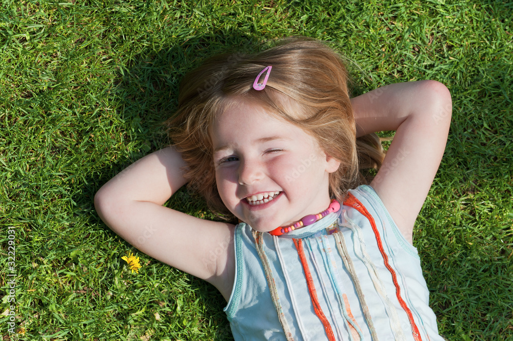 Mädchen liegt auf dem Rasen