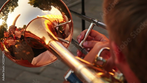man playing trumpet music sitting on sunny summer day