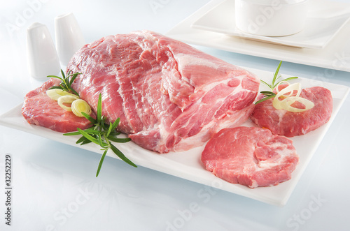 Raw chuck steak with tableware on white background photo