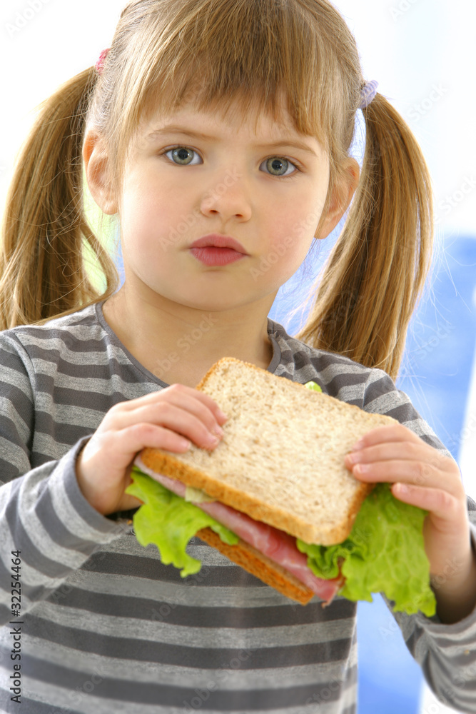 Petite fille avec un sandwiche au jambon Petite fille avec un sandwiche au jambon