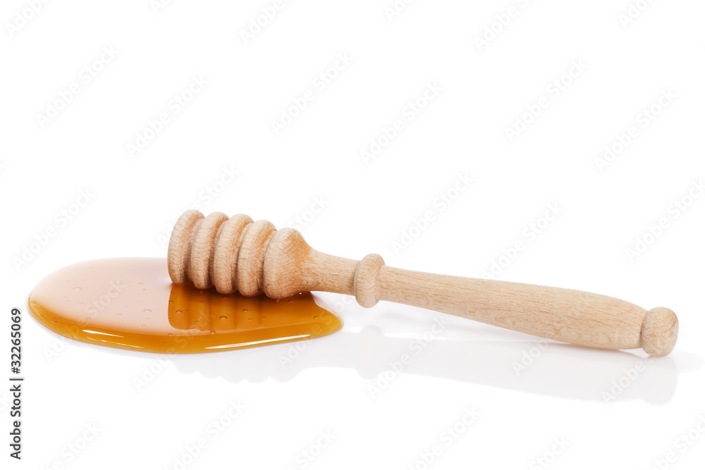 honiglöffel in honig vor weissem hintergrund honiglöffel in honig vor weissem hintergrund