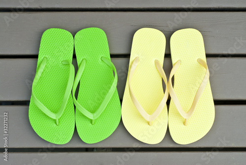 Two Pairs of Colorful Flip Flops on a Deck