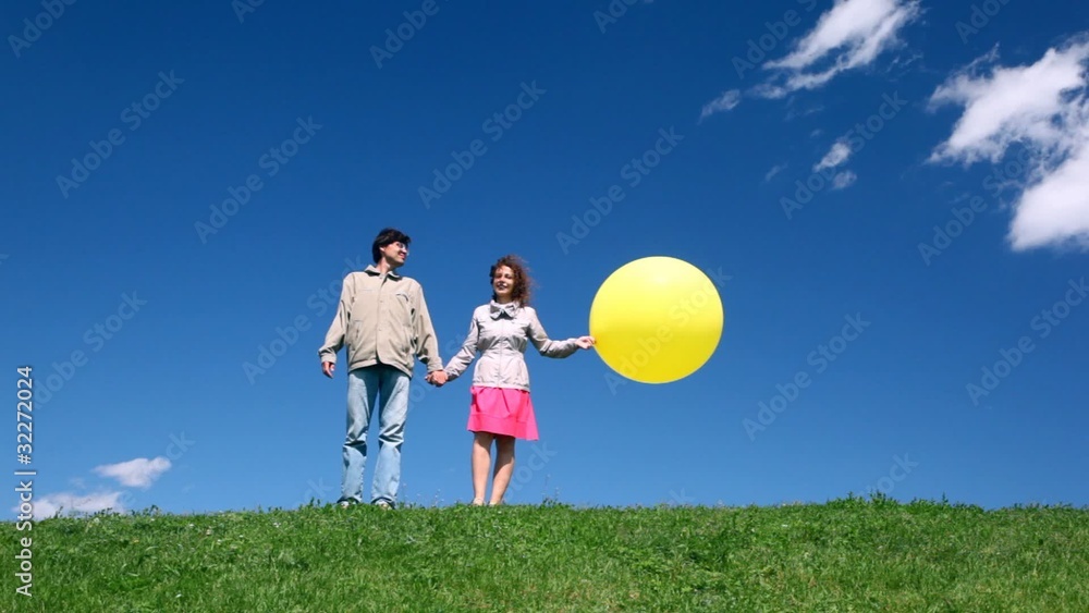man with woman holding hands with yellow bubble stand on hill man with woman holding hands with yellow bubble stand on hill