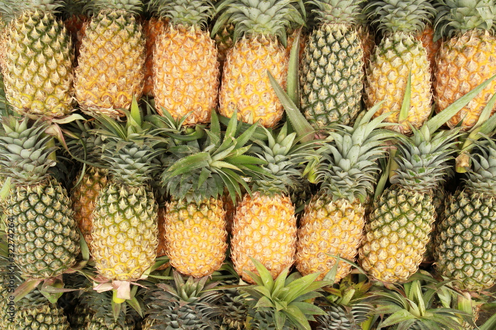 Pile of pineapples at a market stall Pile of pineapples at a market stall
