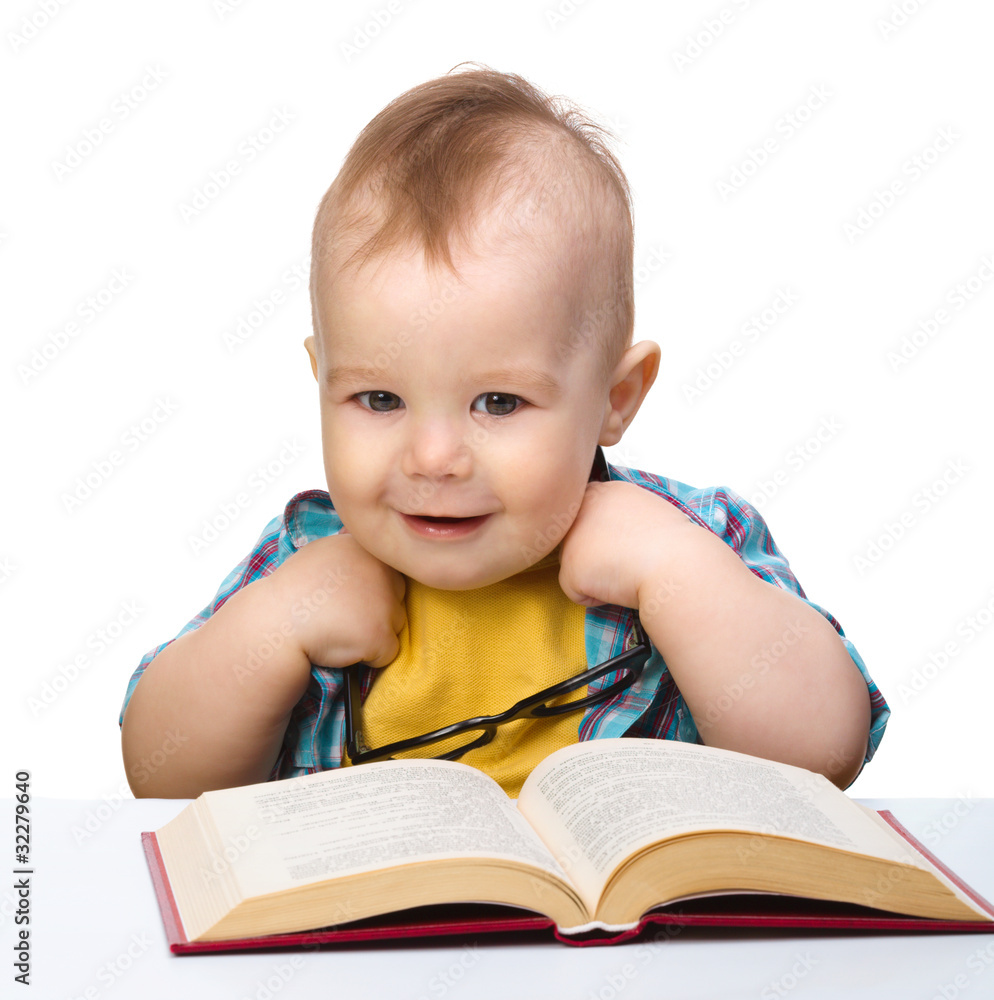 Little child play with book and glasses Little child play with book and glasses
