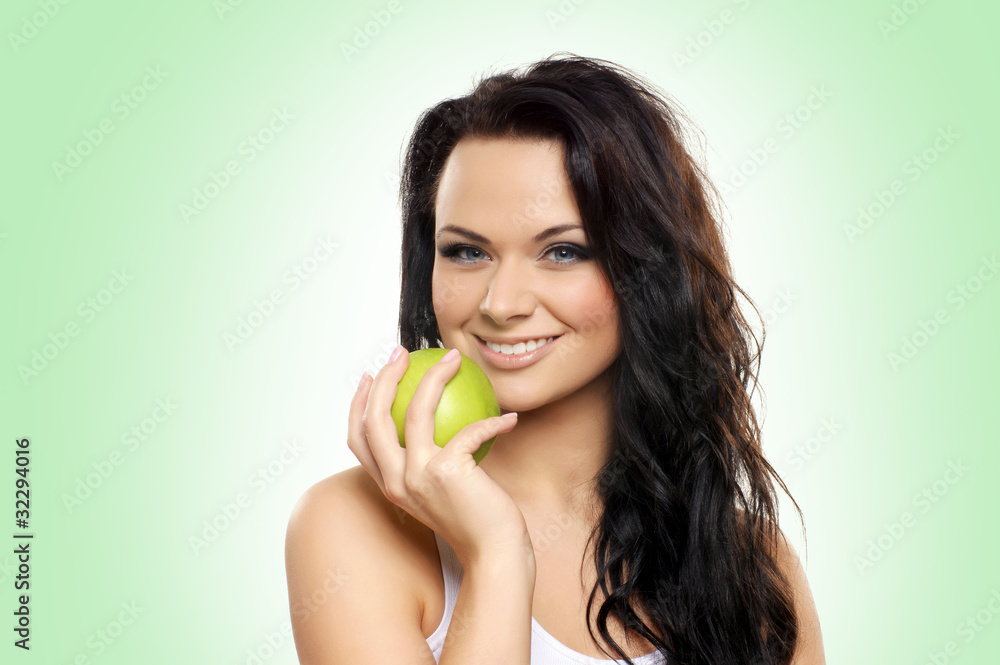 Portrait of a young and attractive woman holding a green apple Portrait of a young and attractive woman holding a green apple