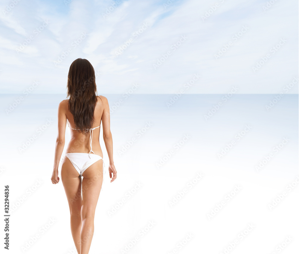 Sexy back of a young brunette woman in a white swimsuit Sexy back of a young brunette woman in a white swimsuit