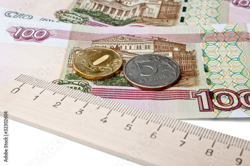 coins, banknotes and a ruler - the concept of the ruble rate