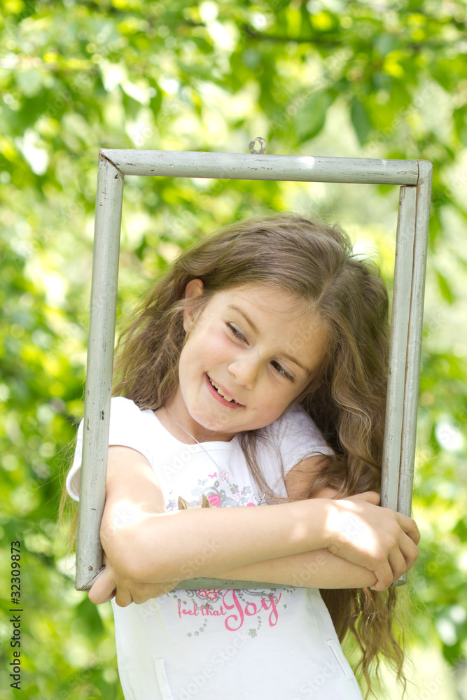 little girl looking throgh wooden frame - beautiful nature backg little girl looking throgh wooden frame - beautiful nature backg