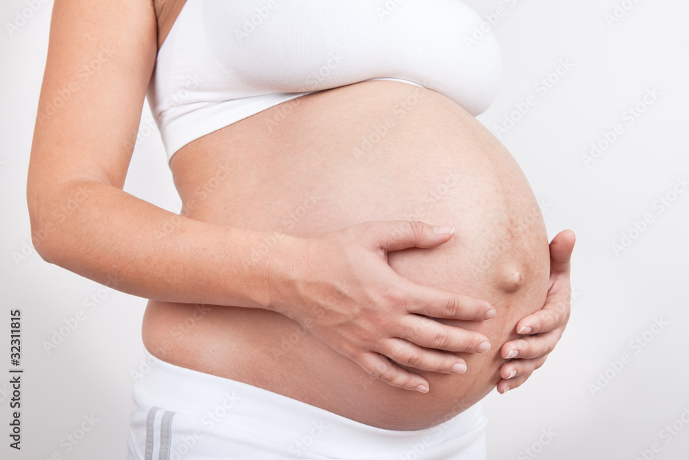 Pregnant woman hold hands on a belly Pregnant woman hold hands on a belly