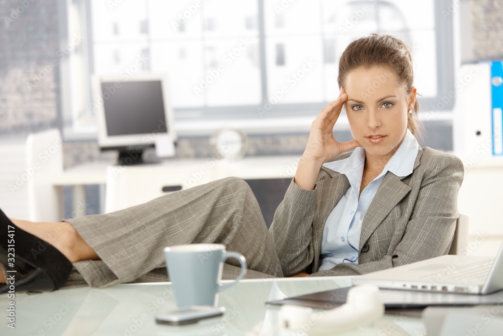 Young businesswoman sitting tired in office Young businesswoman sitting tired in office