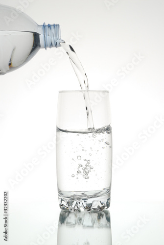 Vaso de agua, vertiendo de botella