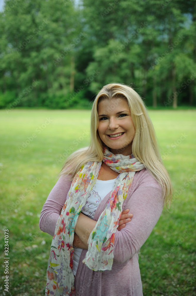 Fototapeta premium Pretty casual woman outdoors in green park smiling