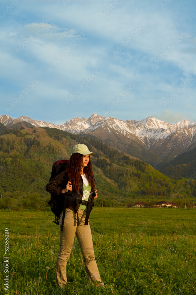 girl with a backpack in the mountains