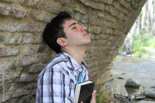 Man Holding Bible Close to Chest photo