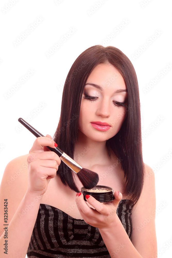 Obraz premium beautiful young brunette woman applying powder with a brush