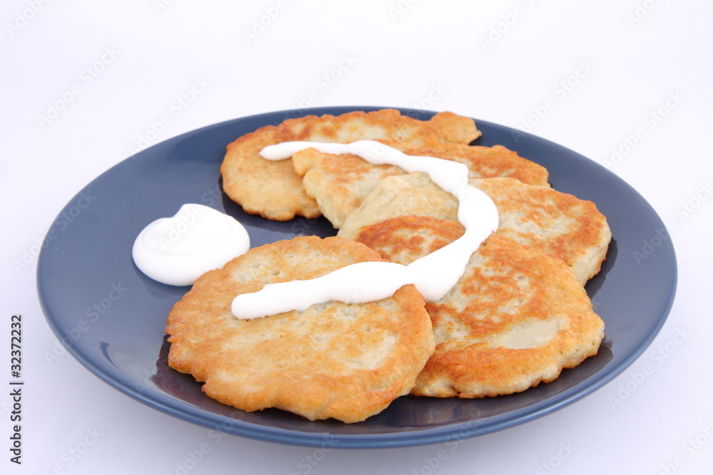 Potato pan cakes with cream on white background Potato pan cakes with cream on white background
