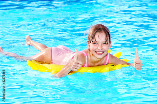 Child sitting on inflatable ring thumb up.