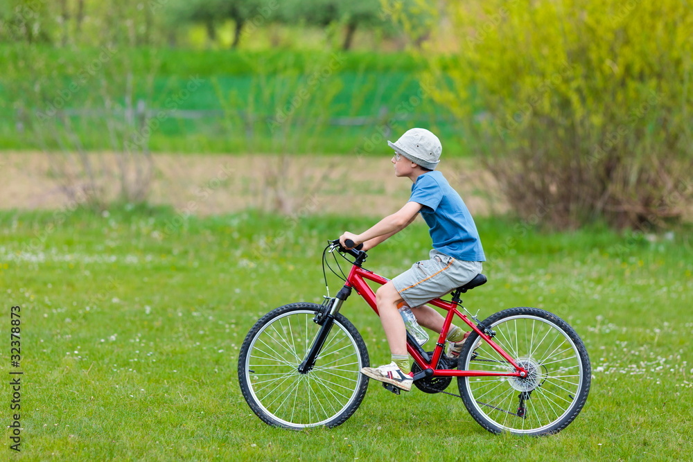 Fototapeta premium Boy with hat riding a bicycle