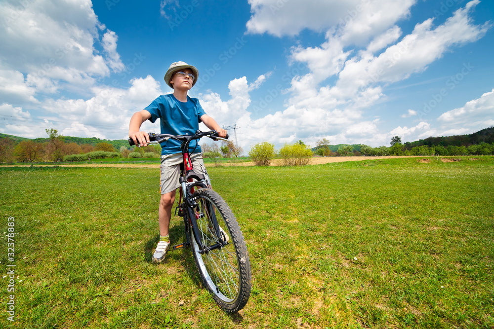 Boy with hat riding a bicycle Boy with hat riding a bicycle