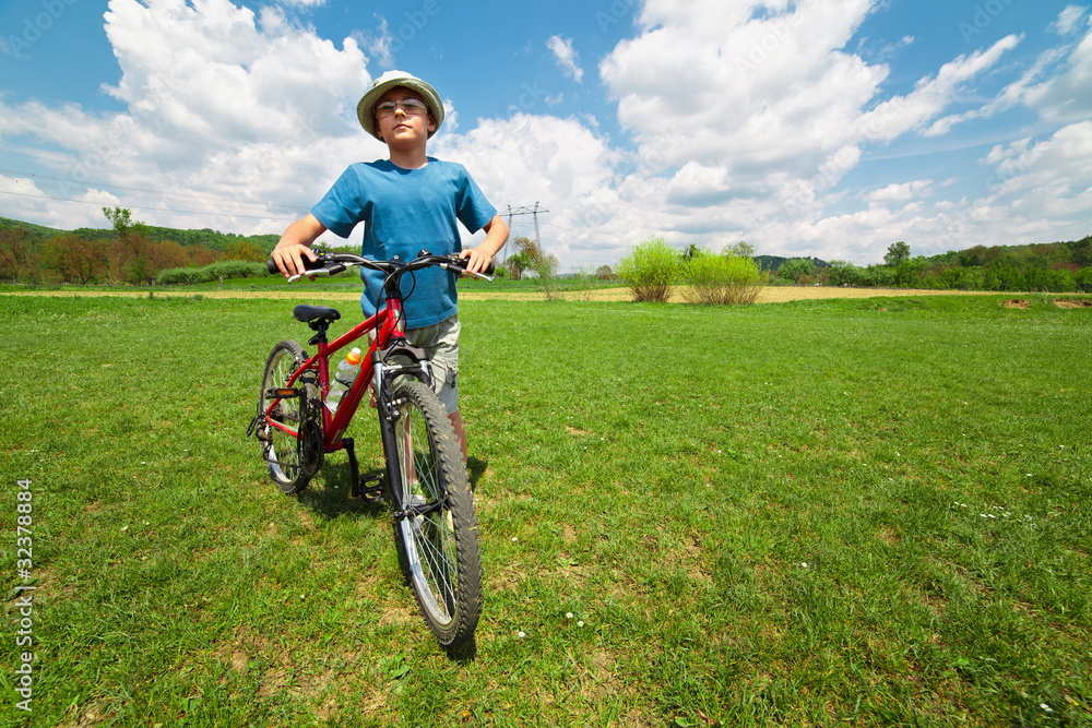 Boy with hat riding a bicycle Boy with hat riding a bicycle