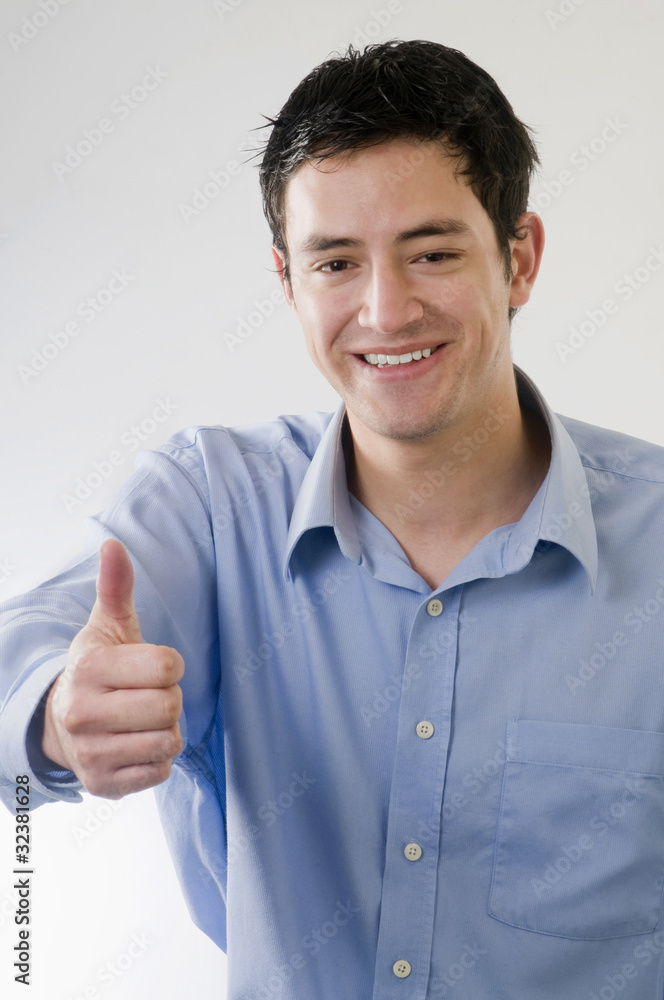 Hombre joven mostrando un pulgar hacia arriba Hombre joven mostrando un pulgar hacia arriba