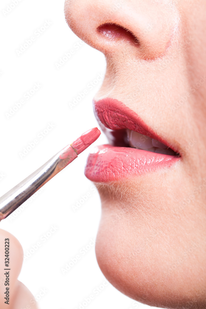 Visagistin beim auftragen von Lippenstift