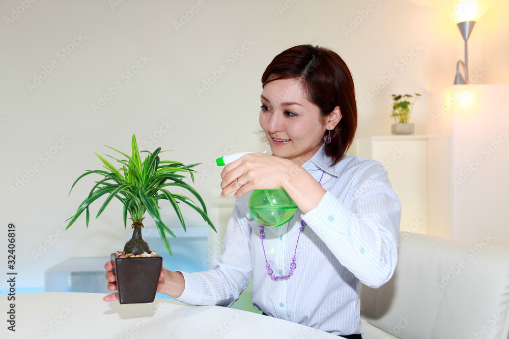 観葉植物の世話をする笑顔の女性